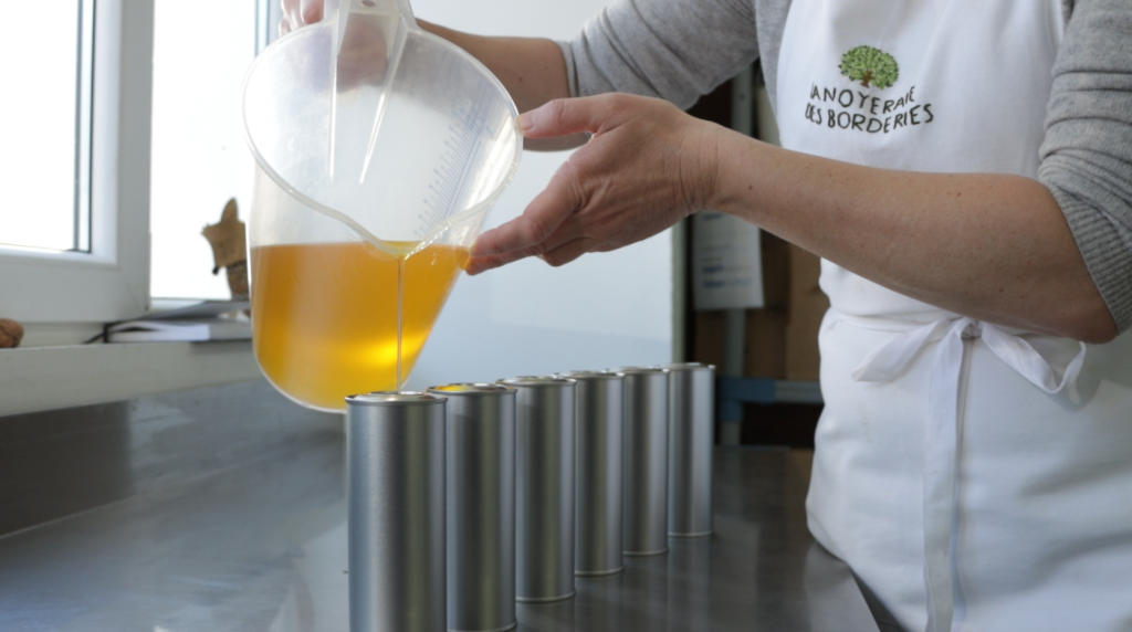 Mise en bouteille artisanale de l'huile de noix au domaine de la Noyeraie des Borderies